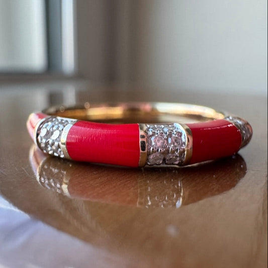 Red ring with gold and diamond accents on a wooden surface