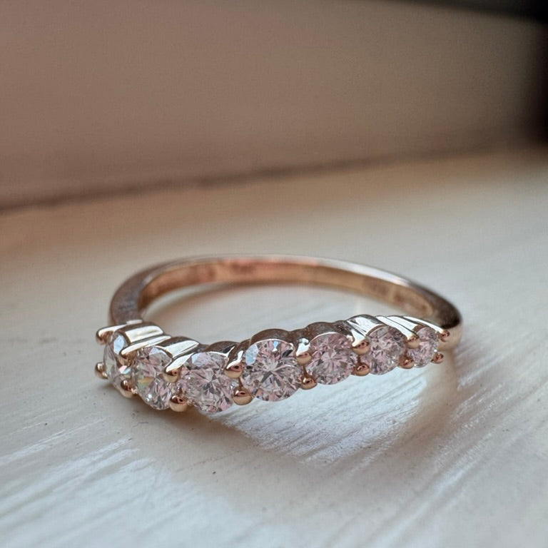 Yellow gold ring with diamonds on a light wooden surface