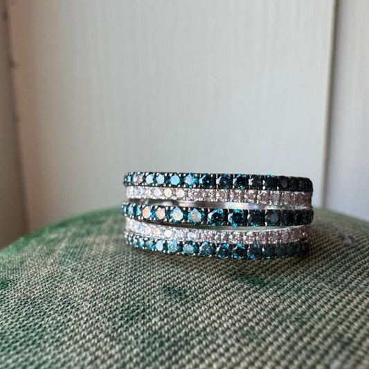 Stack of three bracelets with blue and silver stones on a textured surface