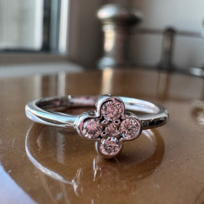 white gold ring with diamonds on a reflective surface