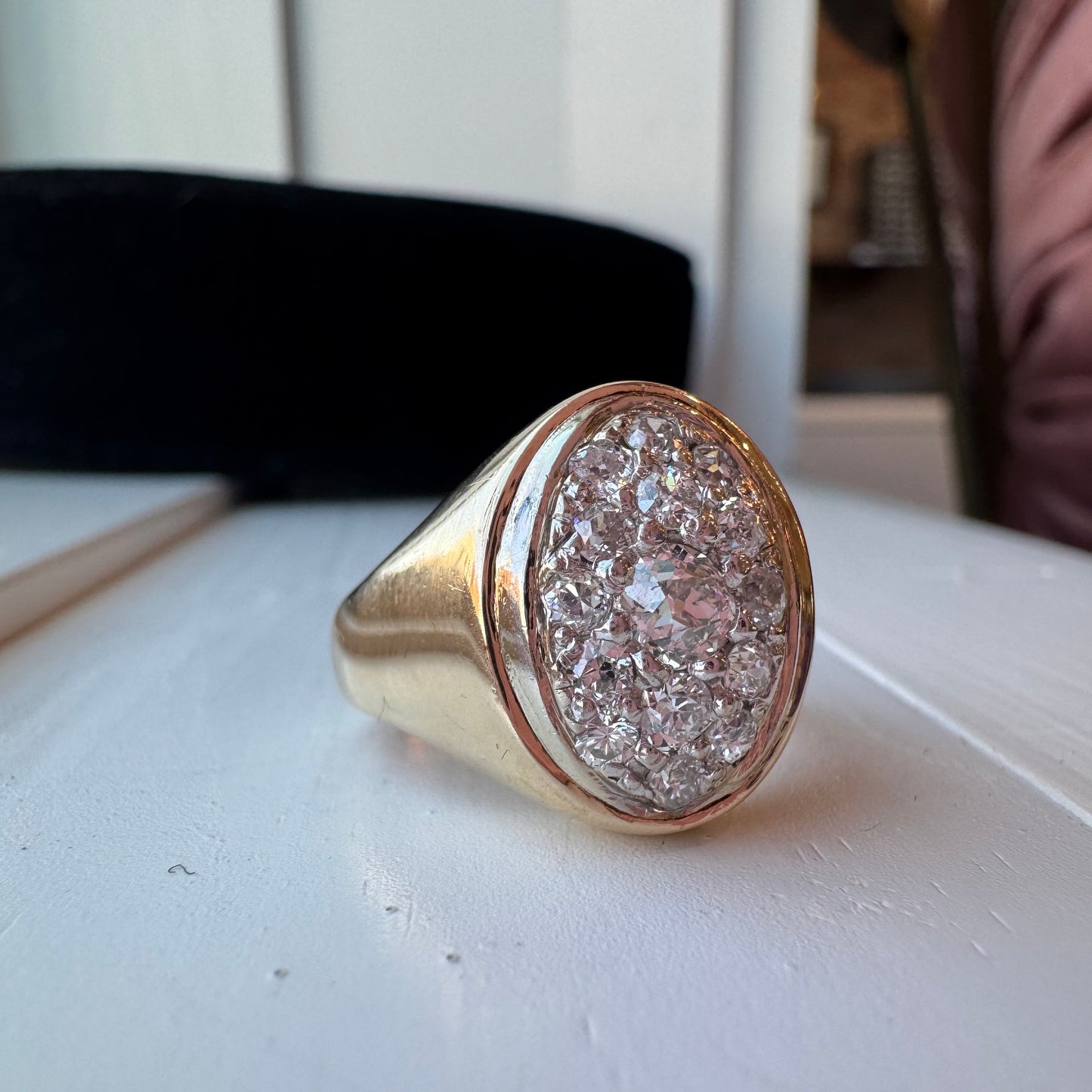 Gold ring with diamond-like material on a white surface