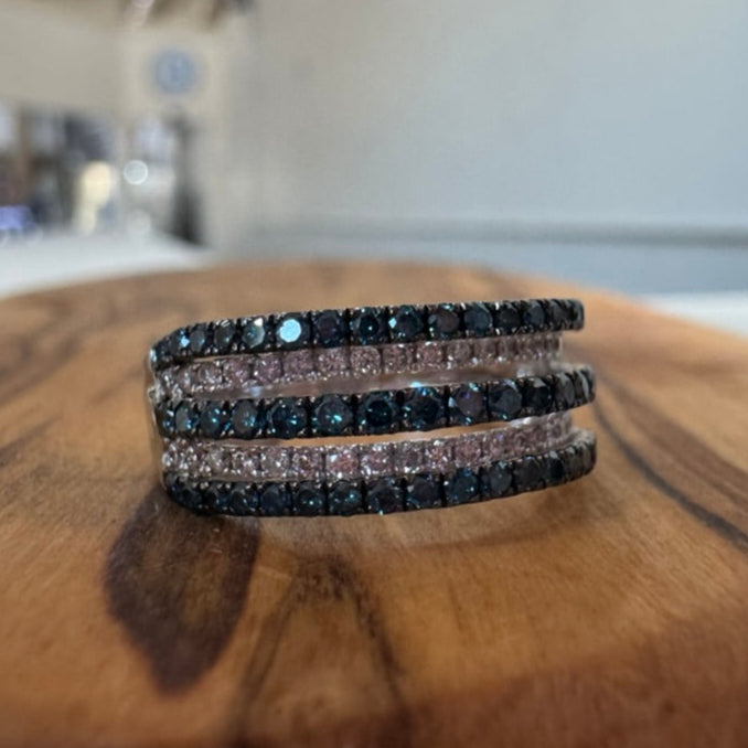 Stack of black beaded bracelets on a wooden surface with a blurred indoor background