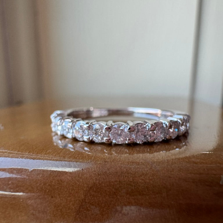 10k white gold ring with diamonds on a reflective surface