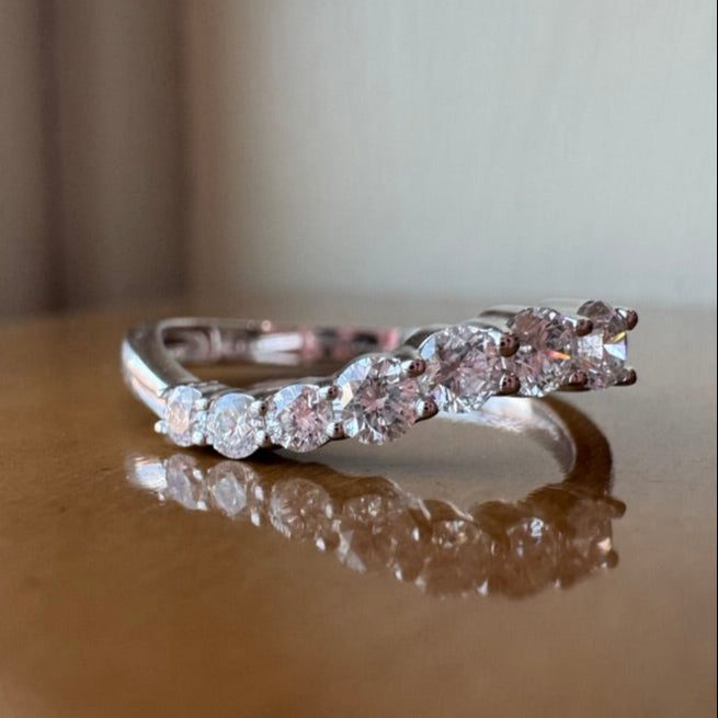 White gold ring with diamonds on a reflective surface