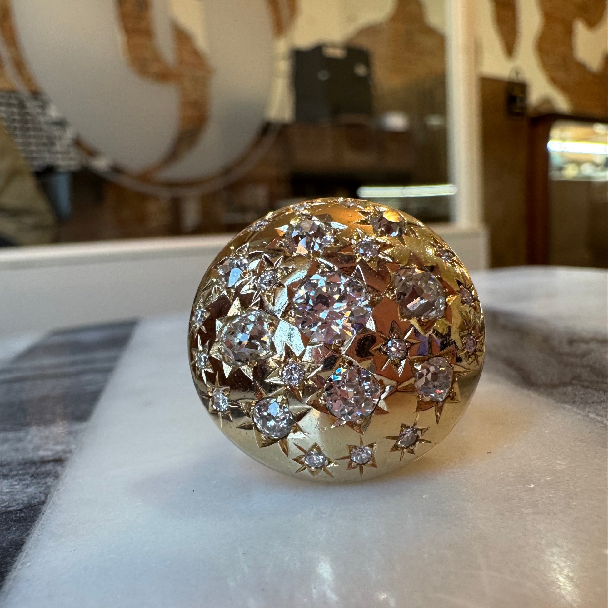 Gold ring with diamonds on a marble surface